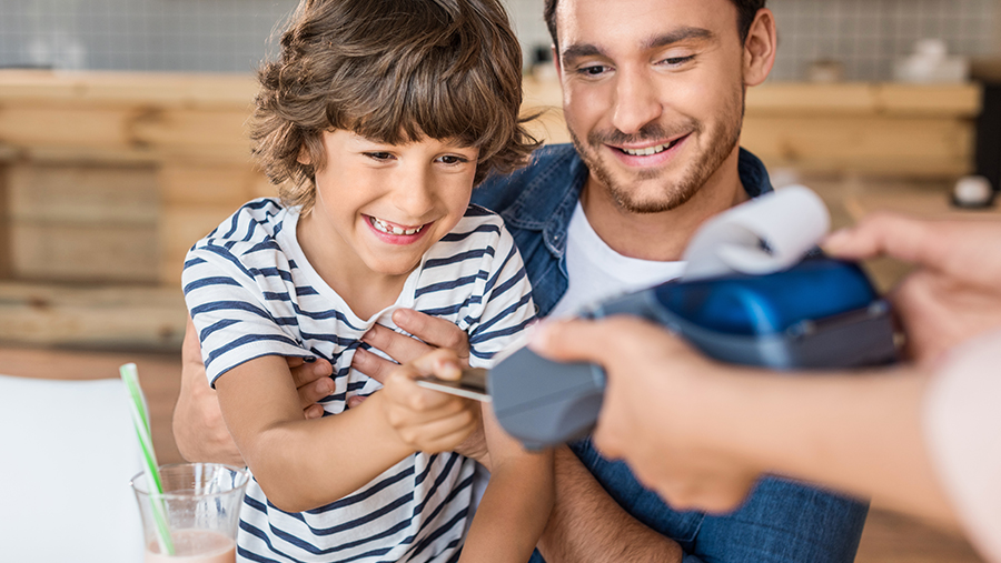 Father and son using debit card