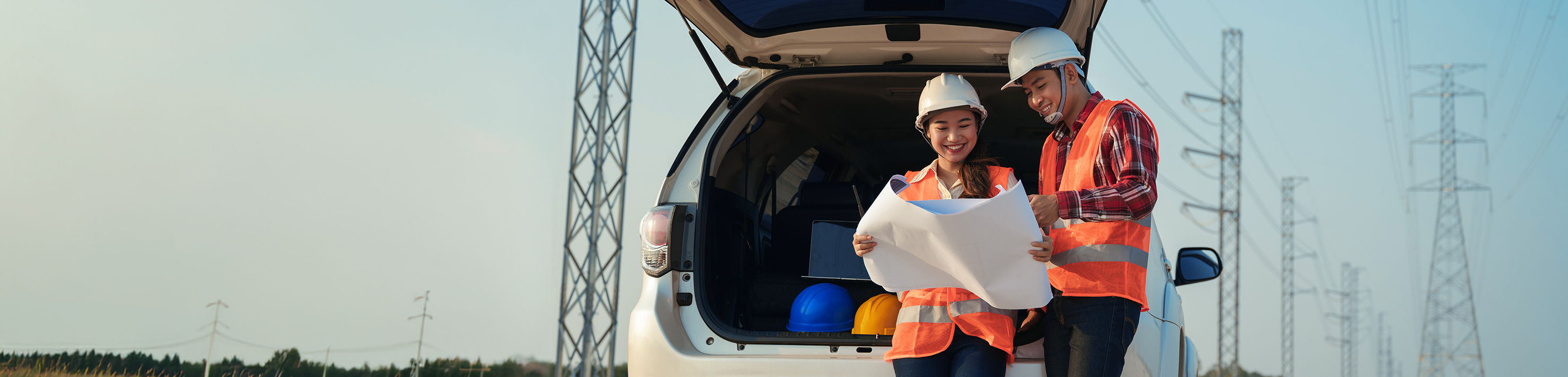 Man and a woman with van with hard hats