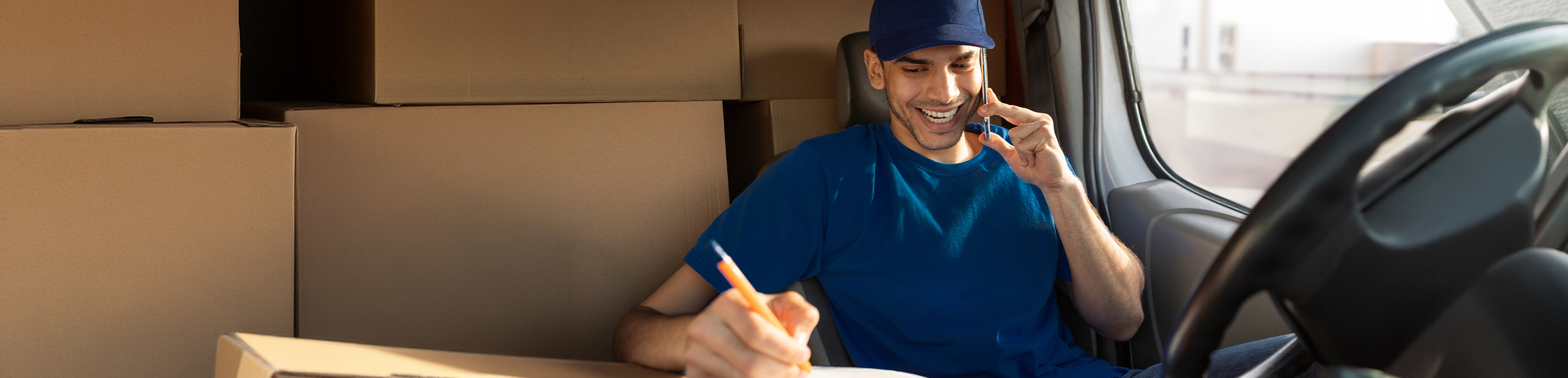 Man on phone in van checking off list