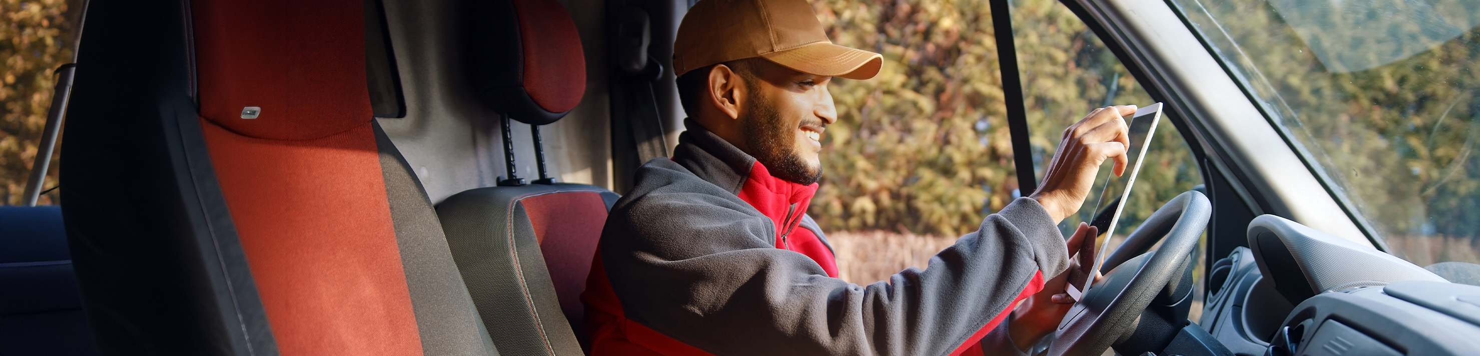 Man in van with box smiling