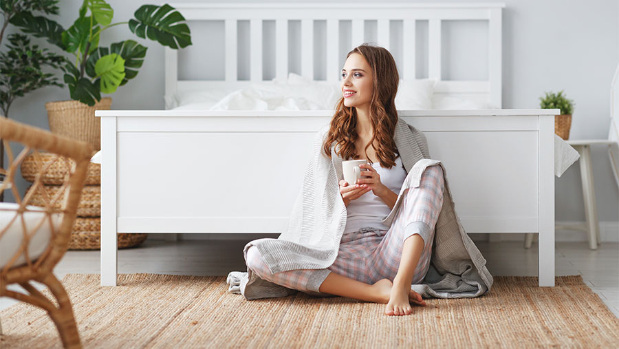 Woman drinking tea by her bed
